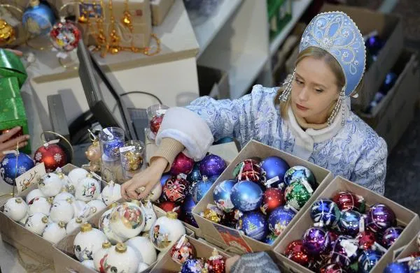 Продавец в костюме Снегурочки на новогодней ярмарке в Торговом доме «ГУМ» в Москве