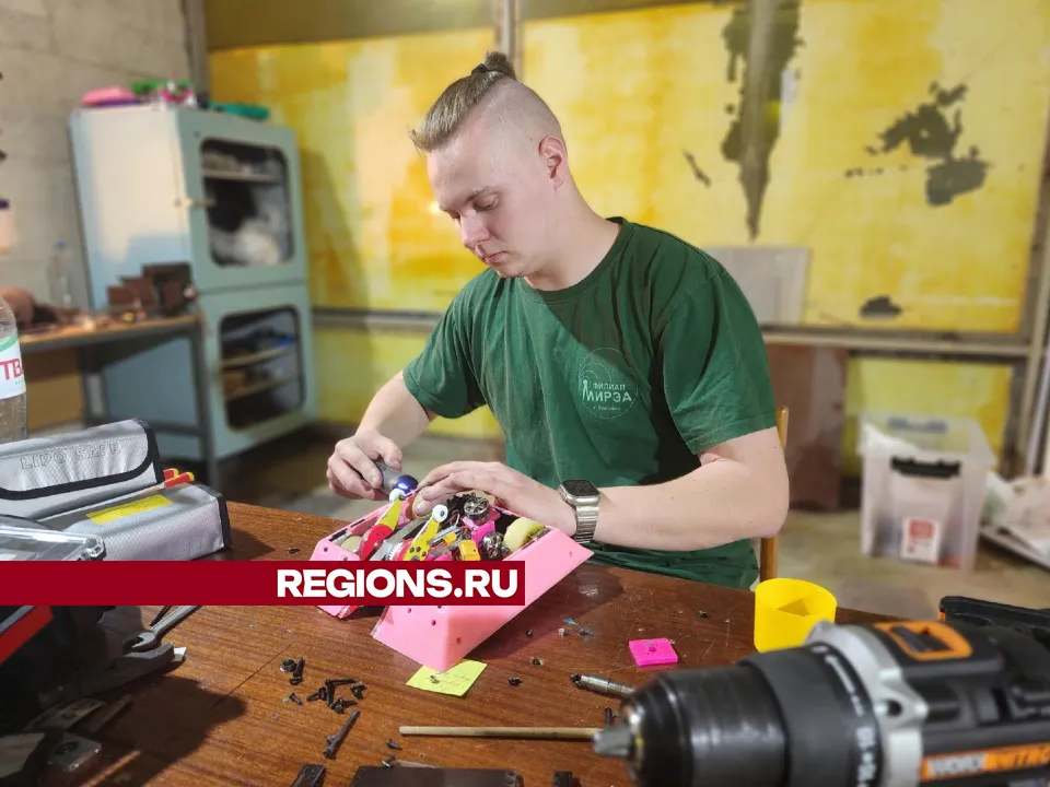 Максим Бобров ремонтирует робота после соревнований. Фото: REGIONS/Наталья Дорошева
