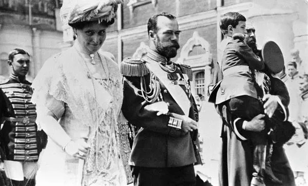 Российский император Николай II, императрица Александра Федоровна и цесаревич Алексей (на руках казака справа) следуют в Малый Николаевский дворец в Кремле