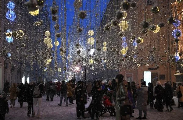 Люди на Никольской улице в Москве, украшенной к Новому году