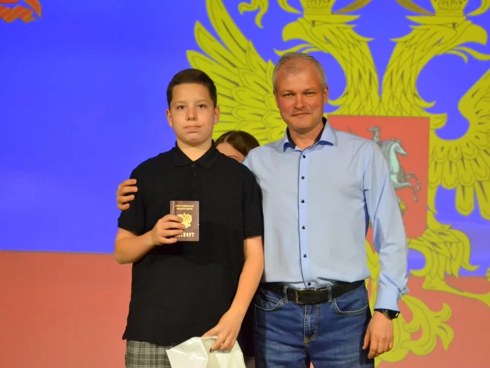 Заместитель главы Краснознаменска Владимир Парамонов вручает первый паспорт РФ. Фото: администрация г.о. Краснознаменск