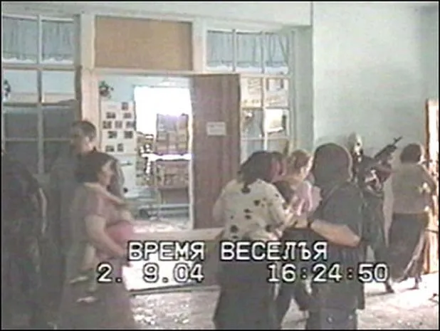 Заложницы с грудными детьми покидают здание школы 2 сентября 2004. После напряженных переговоров с террористами Руслану Аушеву (второй слева) удалось добиться освобождения 24 человек