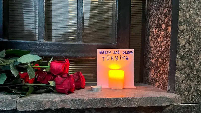 Москвичи несут цветы и свечи к посольству Турции, скорбя по погибшим после землетрясений