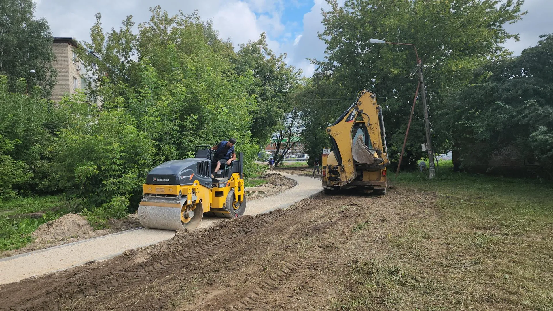 На спецмашинах выравнивают землю на месте, где меняли трубы. Фото: Роман Кутузов