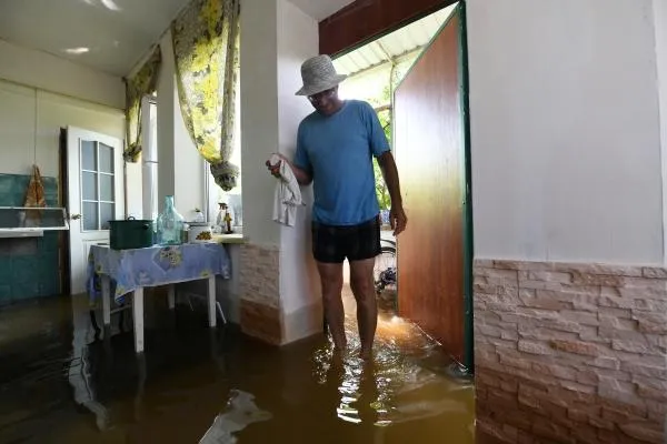 Местный житель внутри жилого дома на подтопленном садовом участке в Новой Каховке после разрушения Каховской ГЭС