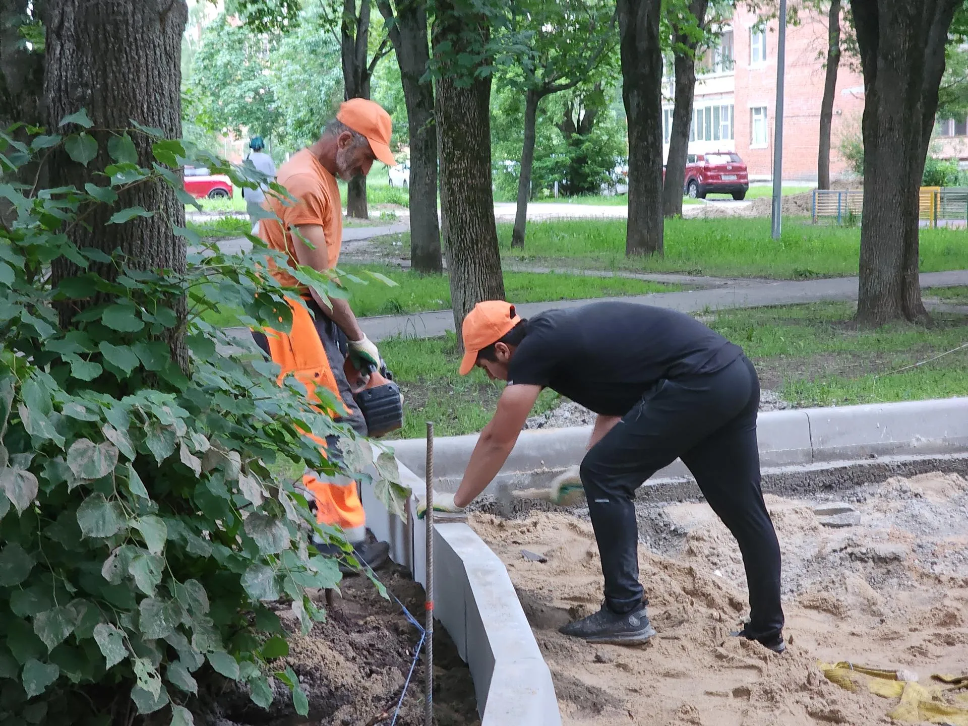 Рабочие устанавливают бордюры во дворах на Центральной улице. Фото: Иван Петрушин