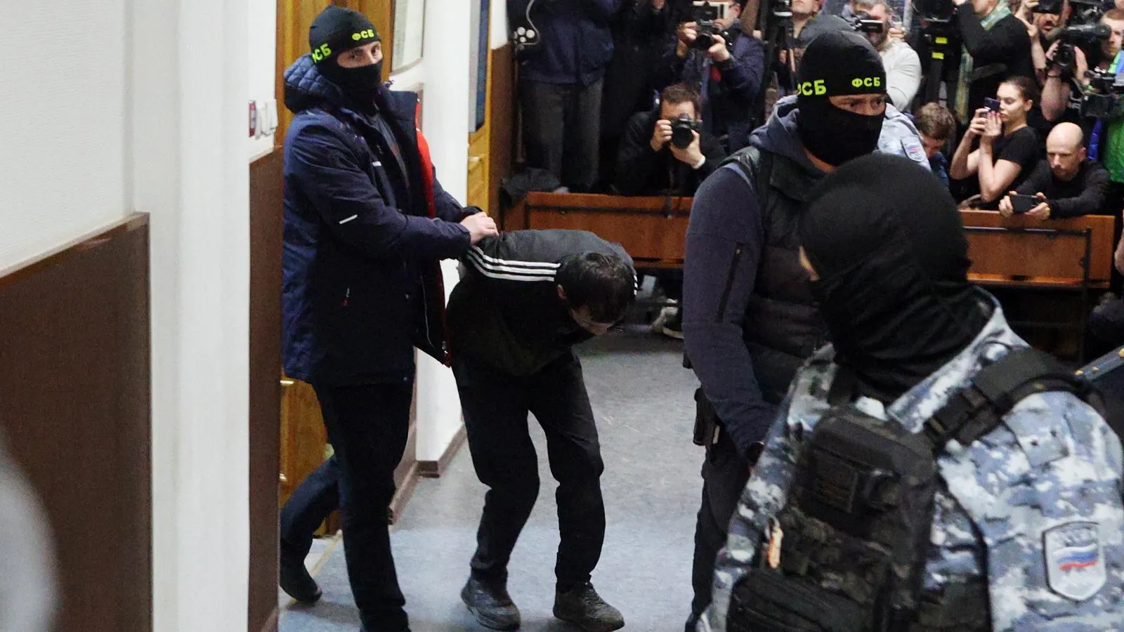 Одного из подозреваемых заводят в зал суда. Фото: Alexey Belkin