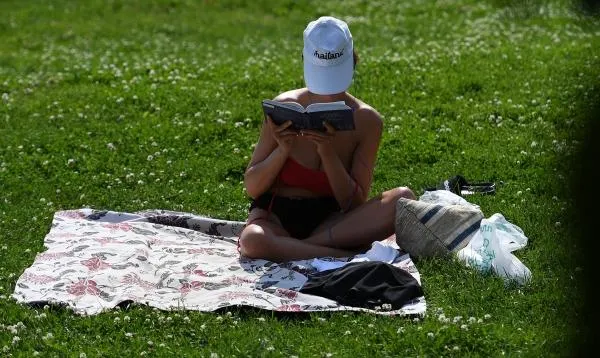 Девушка читает книгу в жаркую погоду в парке Горького в Москве, 2022 год