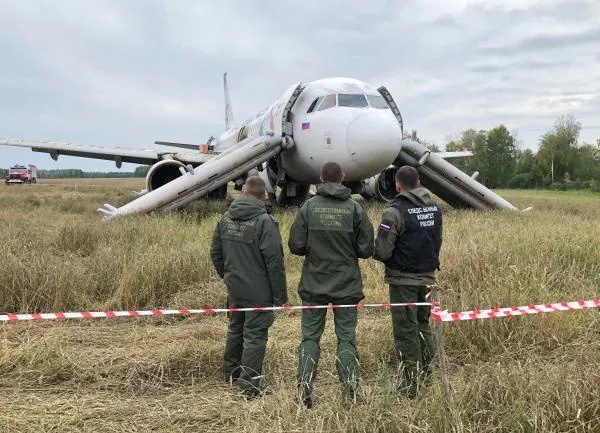 Сотрудники СК возле самолета авиакомпании «Уральские авиалинии», совершившего аварийную посадку на грунт в Убинском районе Новосибирской области
