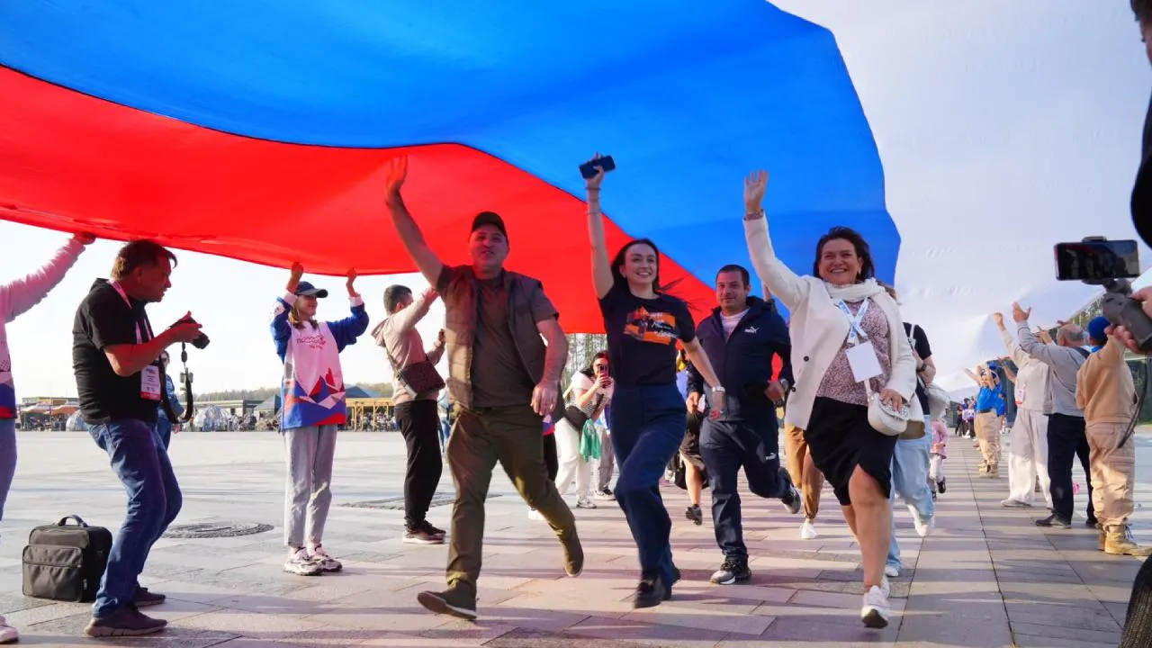 Гости из новых регионов с региональными активистами растянули стометровый флаг в Подмосковье