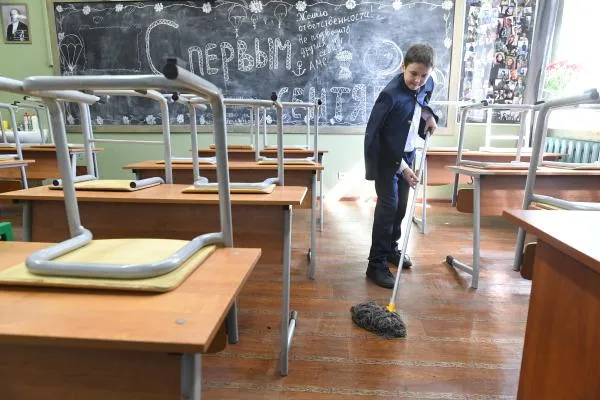 Ученик Православной Свято-Петровской школе в Москве убирается в классе после занятий.