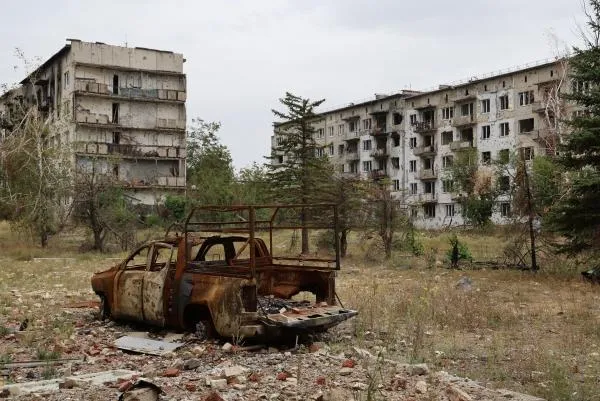 Сгоревший автомобиль у разрушенных в результате боевых действий многоквартирных жилых домов в освобожденной Красногоровке Донецкой Народной Республики, 4 сентября 2024 года.