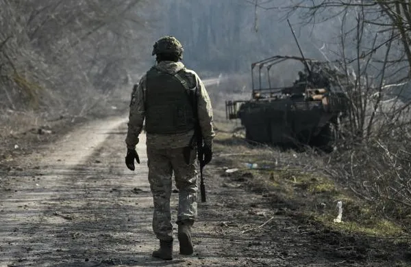 Военнослужащий России рядом со сгоревшим бронеавтомобилем ВСУ БТР-4 «Буцефал» на территории освобожденной деревни Новая Сорочина в Суджанском районе Курской области. Станислав Красильников
