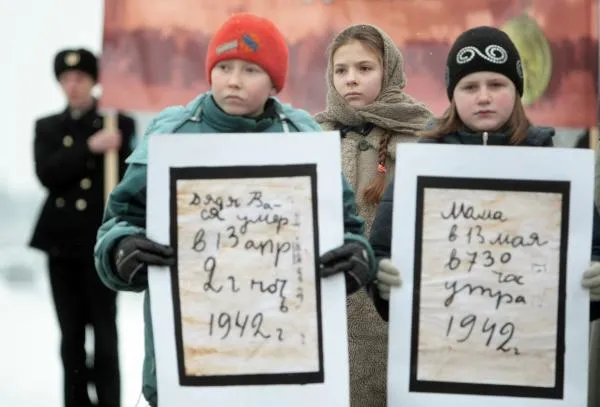 Юные участники акции «Блокадный хлеб» держат плакат со страницами из дневника девочки-блокадницы Тани Савичевой. Акция прошла на Пискаревском мемориальном кладбище в Санкт-Петербурге, 2011 год