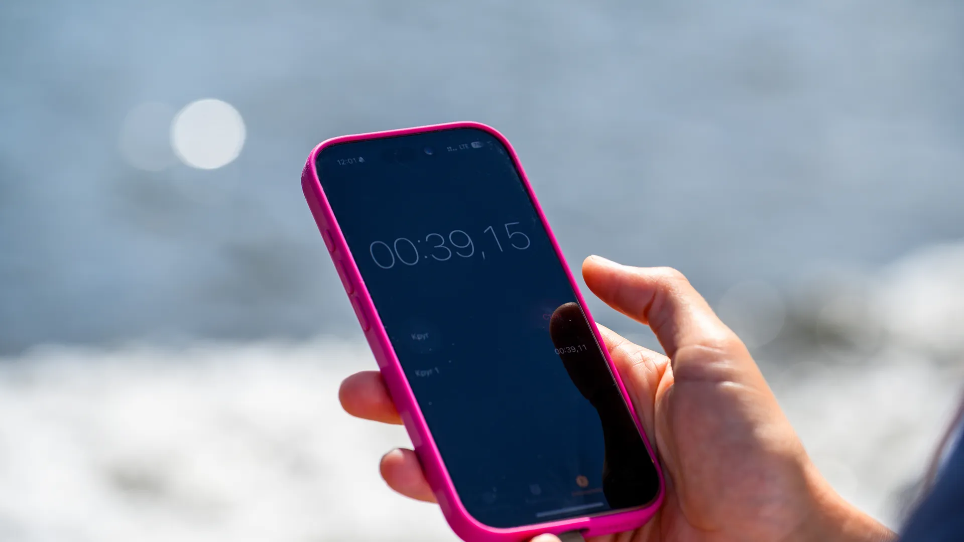 Смартфон с секундомером в руке судьи соревнований