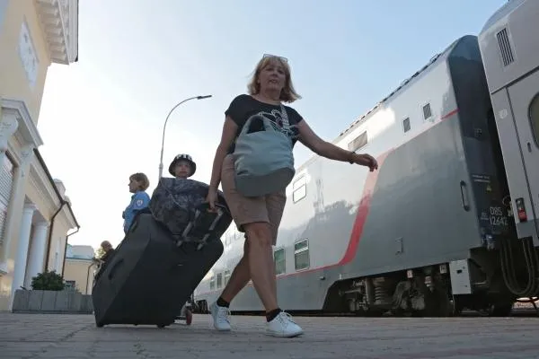 Пассажиры из скорого двухэтажного поезда «Таврия» из Москвы на железнодорожном вокзале Феодосии. «Гранд Сервис Экспресс» запустил между Москвой и Феодосией ежедневный рейс