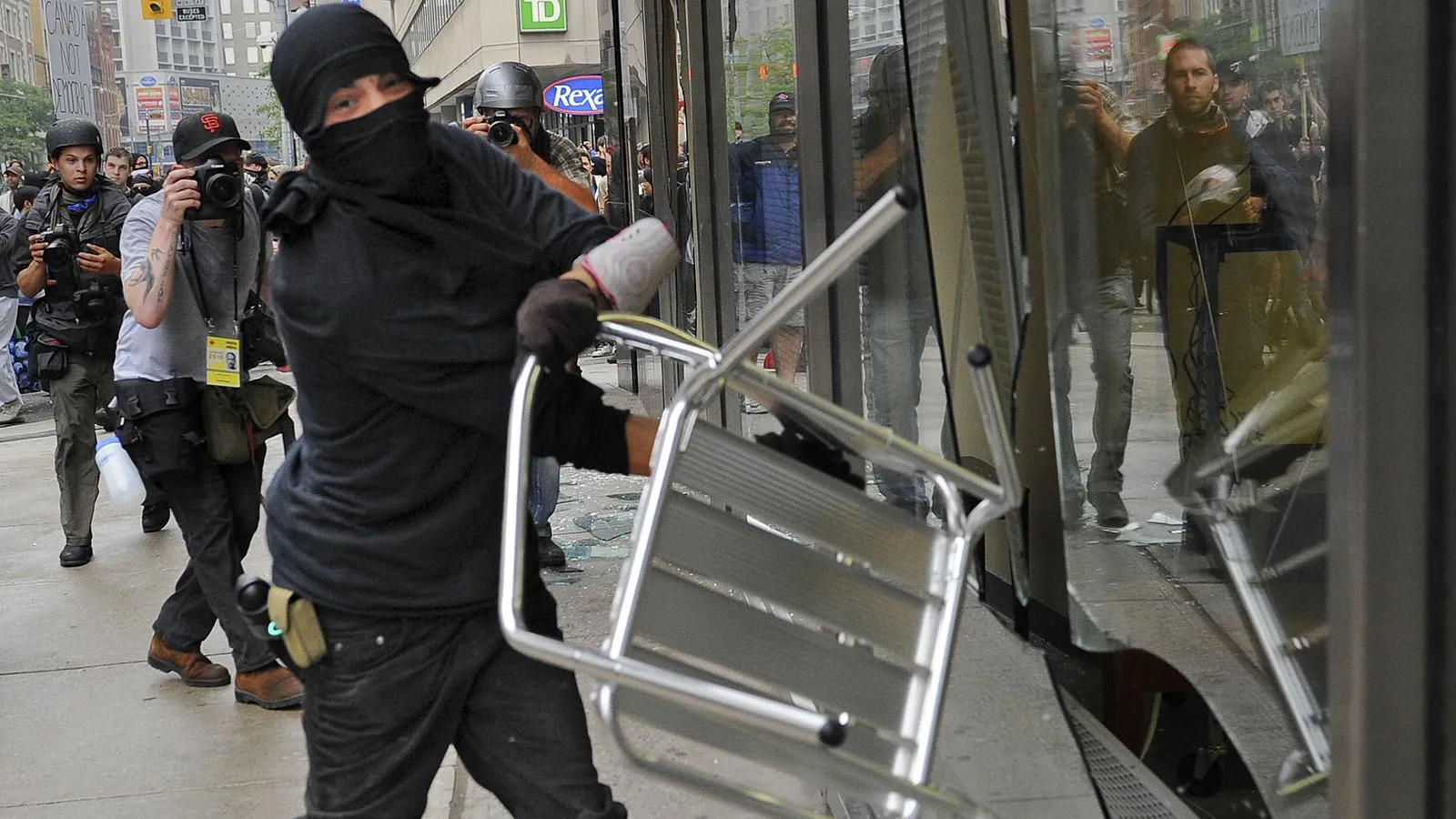 Погромщик Black Bloc разбивает окно банка в Торонто, 2010 год. t14